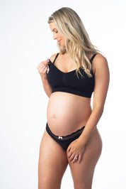 A pregnant woman wearing a black maternity bra with adjustable straps and a nursing design.