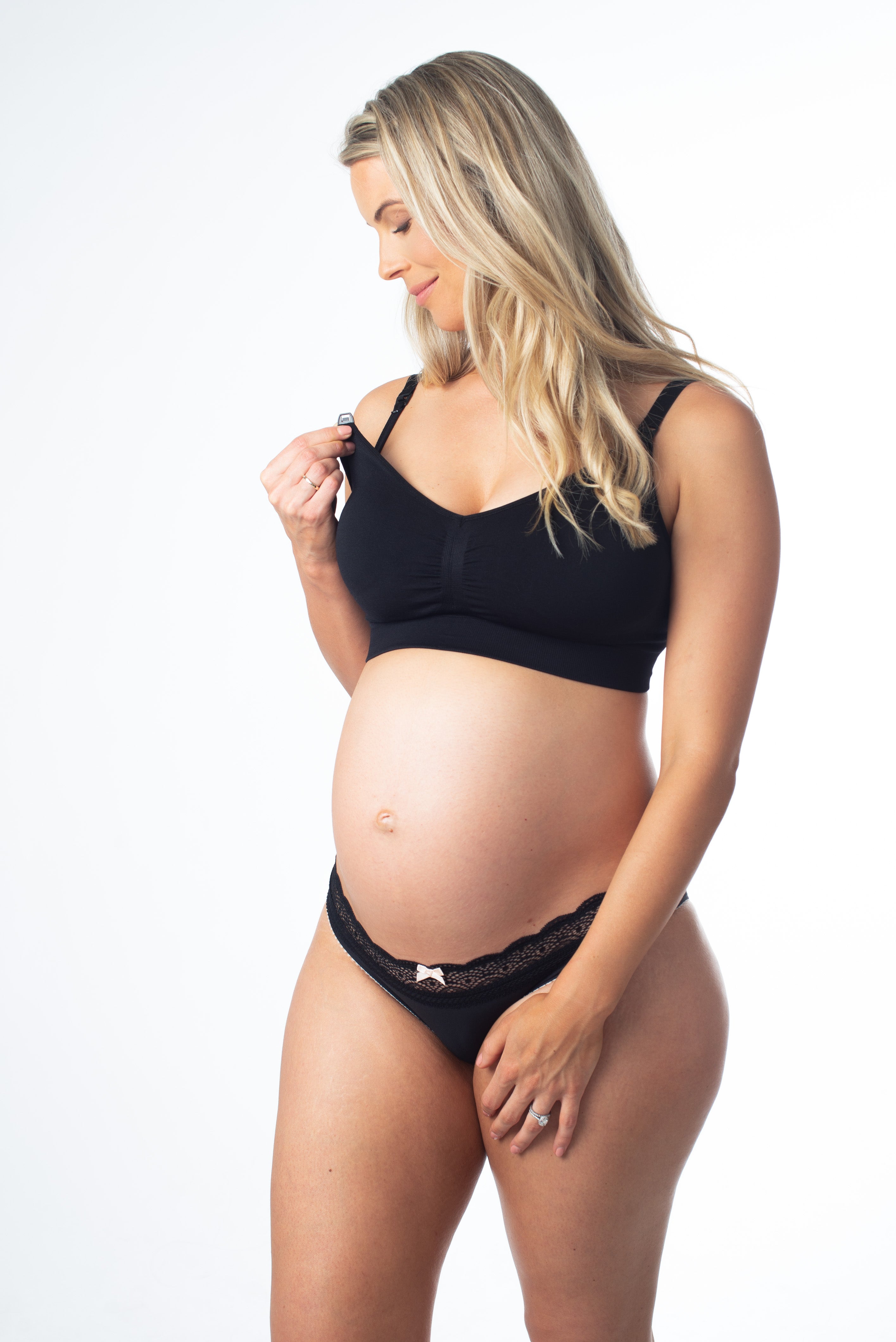 A pregnant woman wearing a black maternity bra with adjustable straps and a nursing design.