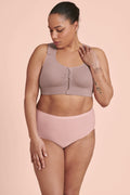 A woman wearing a mauve Anita Almeria Compression Bra, designed for post-surgery support, with a front zip closure and wide, adjustable straps.