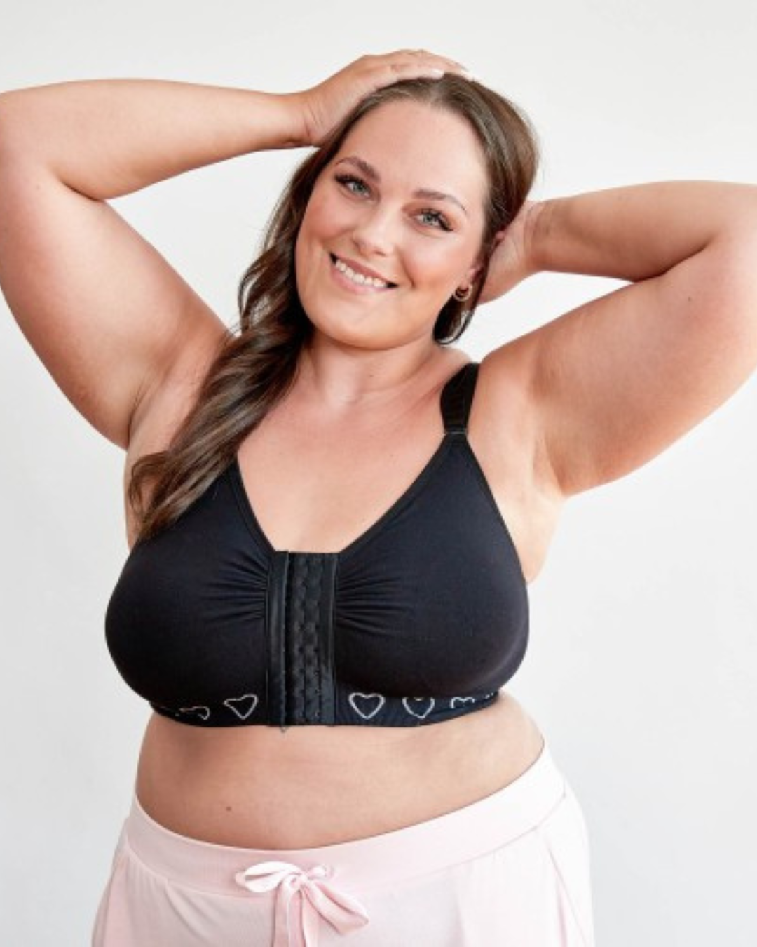 woman wearing a black post mastectomy bra by cancer research with wide straps and bi lateral pockets for mastectomy recovery 