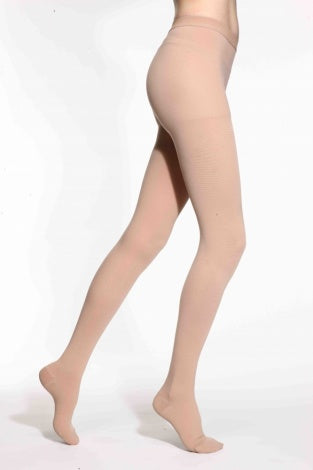 Beige sheer compression stockings worn by a model on a white background