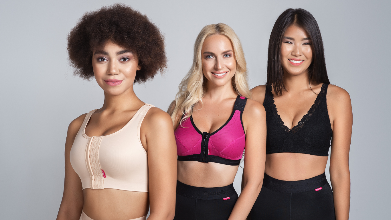 Three Ladies wearing Lipoelastic garments, from the left, the lady is wearing the PI ideal . the lady in the middle is wearing the pink PI unique which is a second stage post surgery bra and the lady on the right is wearing the PI premium which is lace 