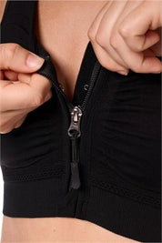 Amoena post surgery bra, Emilia,  an adjustable strap bra with bilateral pockets for prosthesis, front zip closure, and integrated mesh panels. It is suitable for breast surgeries like reconstruction, reduction, augmentation, and mastectomy. The garment also features a hook and loop fastener flap for compression belt attachment. Experience gentle support with the Amoena Emilia post surgery bra 